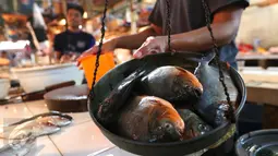 Pedagang menimbang ikan di Pasar Senen, Jakarta, (23/5). Kementerian Kelautan dan Perikanan (KKP) dengan Otoritas Jasa Keuangan (OJK) menargetkan penyaluran kredit untuk sektor kelautan dan perikanan pada tahun 2016. (Liputan6.com/Angga Yuniar)