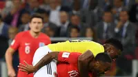 Pemain timnas Inggris, Raheem Sterling berebut bola dengan bek Kolombia, Yerry Mina pada babak 16 besar Piala Dunia 2018 di Stadion Spartak, Selasa (3/7). Sterling menjadi bahan pembicaraan setelah tertangkap kamera menggendong Mina (AFP/YURI CORTEZ)