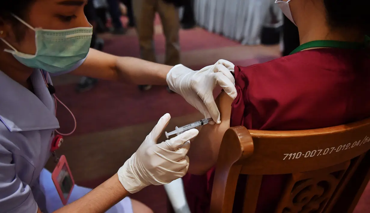 Seorang petugas kesehatan disuntik vaksin COVID-19 CoronaVac dari Sinovac, di Institut Penyakit Menular Bamrasnaradura di Bangkok, Minggu (28/2/2021). Pekan ini, Thailand menerima 200.000 dosis pertama vaksin Sinovac dari China dan 117.00 dosis impor vaksin AstraZeneca. (Lillian SUWANRUMPHA/AFP)
