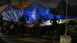 Militer Sri Lanka mencopot tenda dari lokasi kamp protes anti-pemerintah di luar Sekretariat Presiden di Kolombo, Sri Lanka, Jumat (22/7/2022). Ratusan tentara dan pasukan komando polisi bergerak ke arah para pengunjuk rasa di luar kantor kepresidenan Sri Lanka, beberapa jam sebelum mereka akan meninggalkan daerah itu. (AP Photo/Rafiq Maqbool)