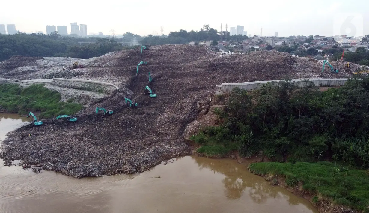 Foto udara memperlihatkan tumpukan sampah dari Tempat Pembuangan Akhir (TPA) Cipeucang masuk ke area Sungai Cisadane, Serpong, Tangerang Selatan, Rabu (3/6/2020). Sebelumnya, pada Jumat (22/5/) lalu turap yang menopang tumpukan sampah di TPA tersebut jebol. (Liputan6.com/Helmi Fithriansyah)