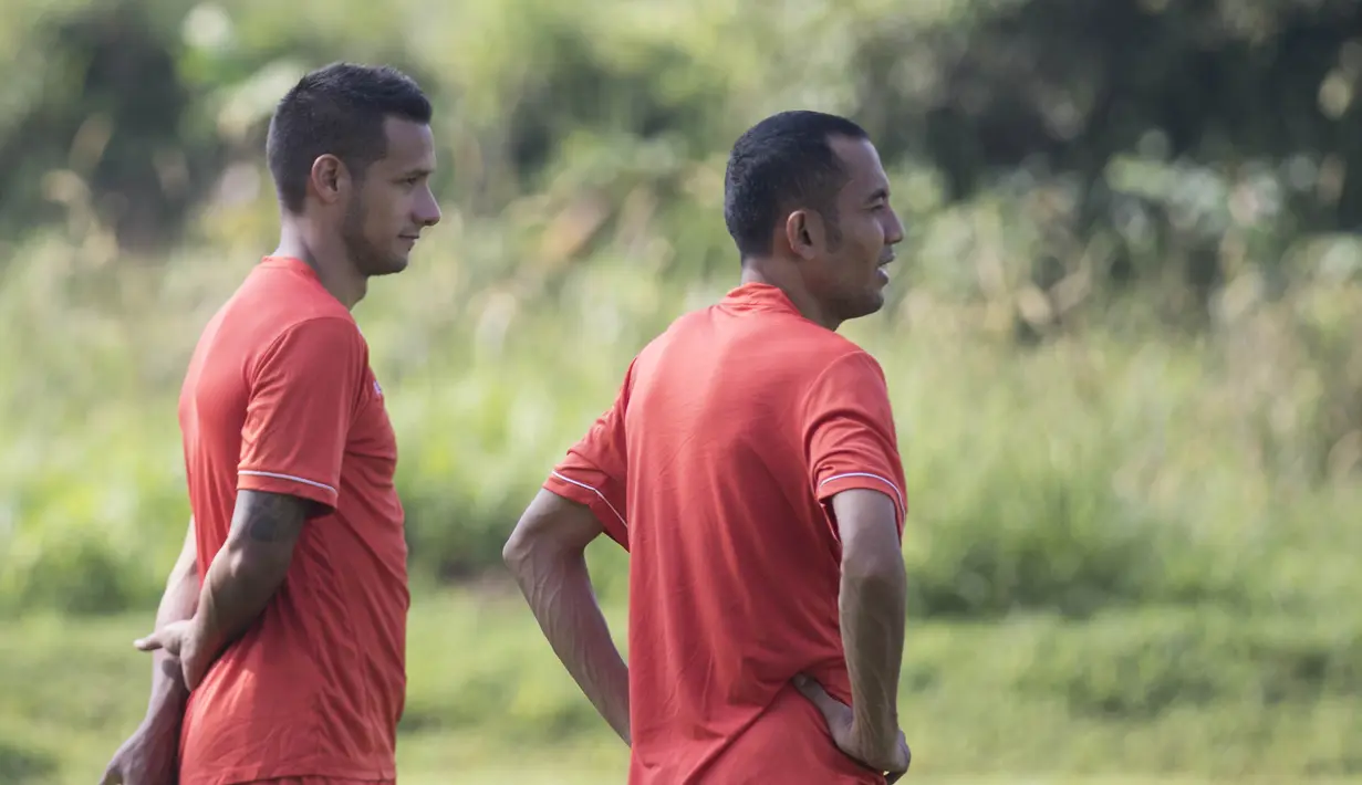 Pemain Persija, Raphael Maitimo, dan Muhammad Ilham, memperhatikan rekan-rekan berlatih jelang babak 8 besar Piala Jenderal Sudirman di Lapangan Sawangan, Depok, Jawa Barat, Senin (7/12/2015). (Bola.com/Vitalis Yogi Trisna) 