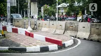 Kendaraan melintas di samping perlintasan sebidang yang sudah ditutup di sekitar Stasiun Palmerah, Jakarta, Senin (30/11/2020). Dinas Perhubungan DKI resmi menutup perlintasan sebidang kereta api tersebut terkait adanya program penataan tahap dua di Stasiun Palmerah. (Liputan6.com/Faizal Fanani)