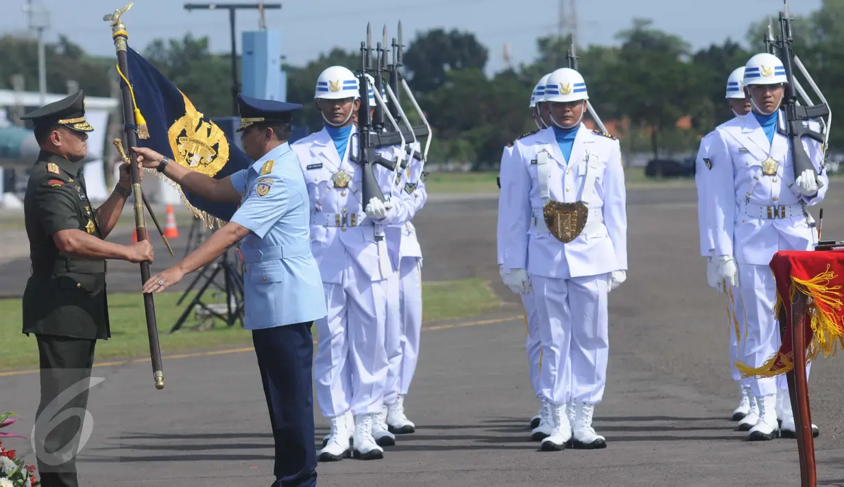 Masekal TNI Agus Supriatna‎ (kanan) menyerahkan pataka TNI AU ke Panglima TNI Jenderal Gatot Nurmantyo di Lanud Halim Perdanakusuma, Jakarta, Jumat (20/1). KSAU Marsekal TNI Agus Supriatna digantikan Hadi Tjahjanto. (Liputan6.com/Helmi Afandi)