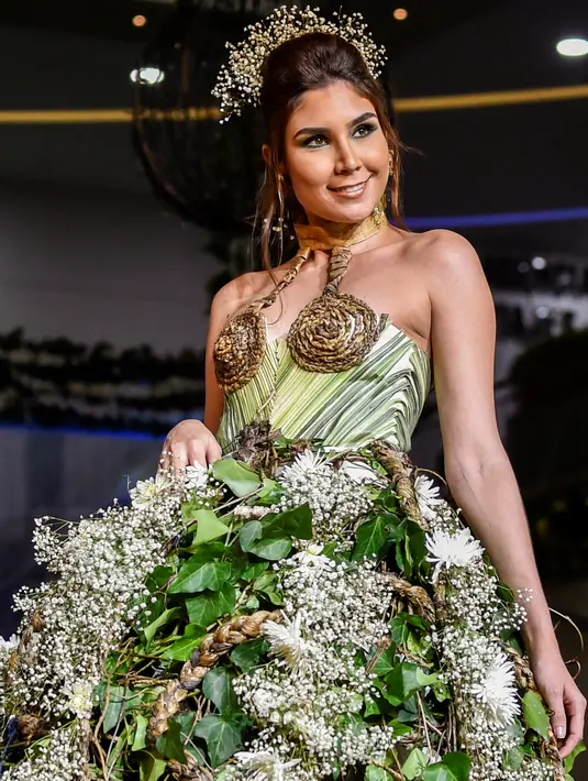Model mengenakan busana rancangan desainer Kolombia, Linda Alegrias selama BioFashion Show di Cali  pada 17 November 2018. Busana-busana yang ditampilkan di ajang ini seluruhnya terbuat dari tanaman hidup, bunga dan unsur organik lain. (Luis ROBAYO/AFP)