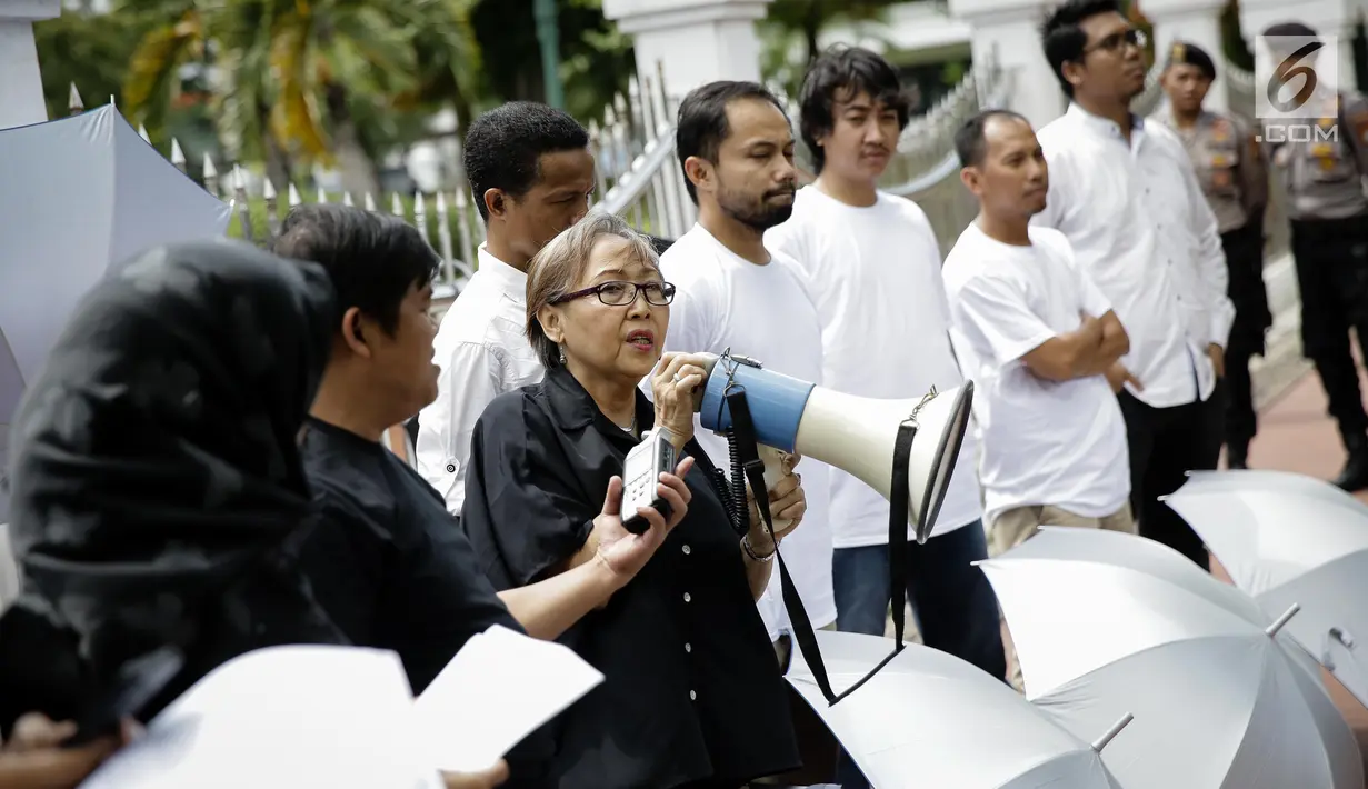 Sejumlah massa saat berorasi di depan Mahkamah Agung, Jakarta, Rabu (7/6). Dalam aksinya mereka menaburkan bungan pada payung sebagai bentuk simbol kekhawatiran matinya keadilan dan penegakan hukum. (Liputan6.com/Faizal Fanani)