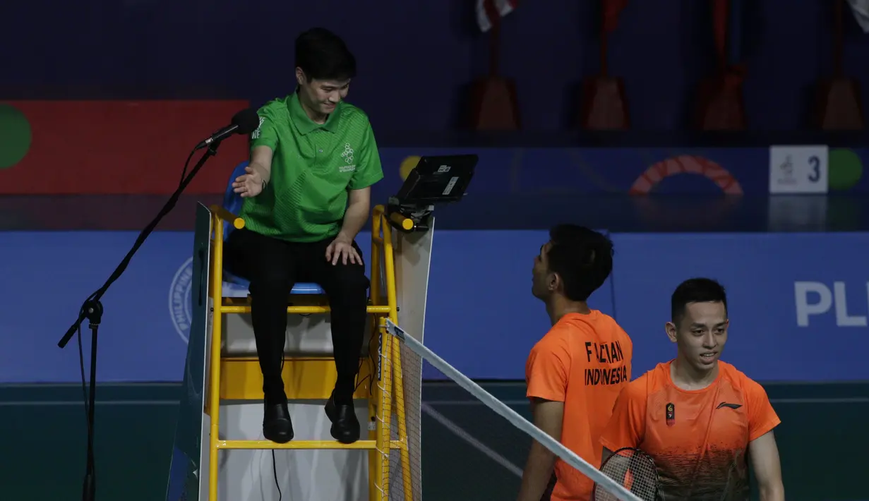 Ganda putra Indonesia, Fajar Rian / Muhammad Rian, melakukan protes saat melawan Aaron Chia / Soh Wooi Yik pada final beregu SEA Games 2019 di Multinlupa Sport Center, Rabu (4/12). Fajar / Rian kalah 17-21 dan 13-21. (Bola.com/M Iqbal Ichsan)