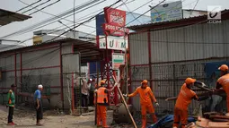 Petugas PPSU membongkar bangunan kios pedagang nasi kapau di Jalan Kramat Raya, Senen, Jakarta, Jumat (6/9/2019). Pembongkaran disebabkan adanya rencana revitalisasi trotoar di jalan tersebut. (Liputan6.com/Immanuel Antonius)