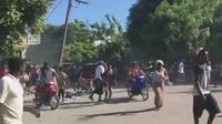 Orang-orang terlihat melarikan diri dari kekerasan geng bersenjata di Haiti dengan sepeda motor dan berjalan kaki. (AP)