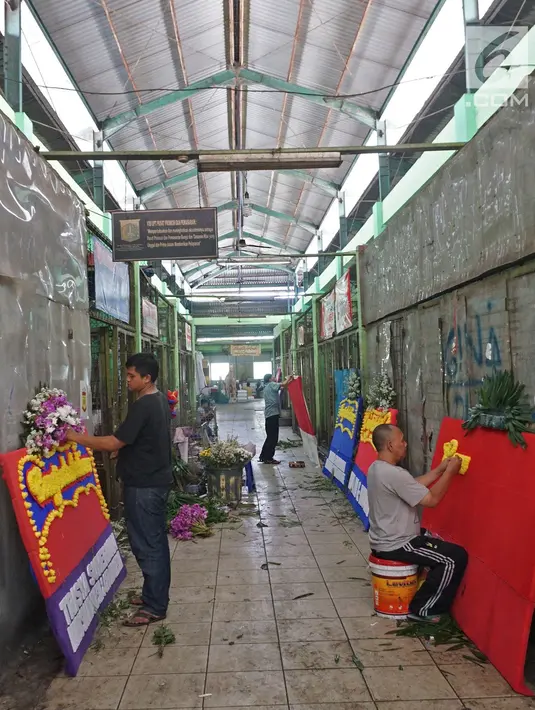 Pekerja membuat pesanan papan karangan bunga di Pasar Rawa Belong Jakarta, Selasa (25/7/2019). Selama proses revitalisasi, sekitar 600 pedagang bunga di pasar itu akan direlokasi ke Pasar Semanan Kalideres, dan Pasar Klender Duren Sawit selama proses pembangunan. (Liputan6.com/Herman Zakharia)