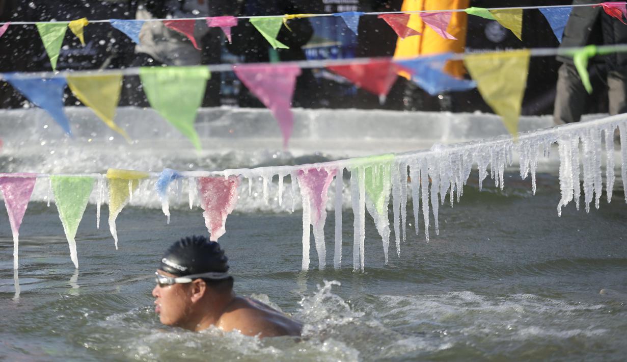 Peserta ambil bagian dalam Kompetisi Renang Es Harbin di Sungai Songhua yang membeku di Provinsi Heilongjiang, China, Senin (5/1/2016). Acara ini diselengarakan dalam rangka pembukaan Harbin International Ice and Snow Sculpture Festival (REUTERS/Aly Song)