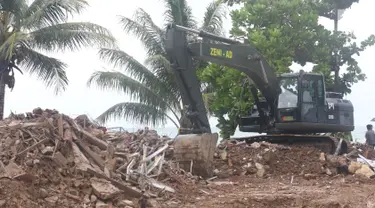 Alat berat melakukan evakuasi bangunan yang hancur akibat terjangan tsunami Selat Sunda di Carita, Banten, Selasa (25/12). Akibat tsunami yang melanda kawasan tersebut menyebakan ratusan rumah dan mobil rusak. (Liputan6.com/Angga Yuniar)