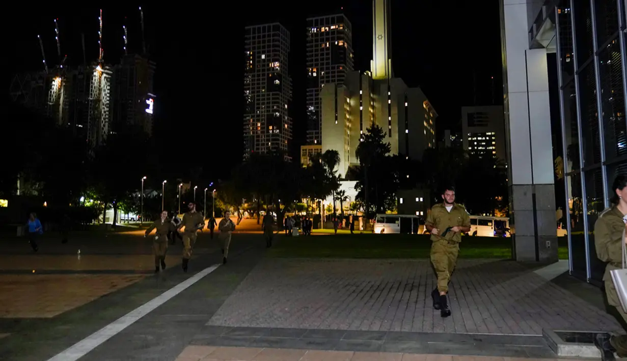 Tentara Israel berlari untuk berlindung ke dalam The Kirya, yang menampung Kementerian Pertahanan Israel, setelah sirene serangan udara dibunyikan di Tel Aviv, Israel, Senin (16/10/2023). (AP Photo/Jacquelyn Martin, Pool)