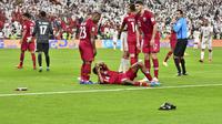 Pemain Qatar, Salem Al Hajri, terbaring karena terkena lemparan sebuah benda saat menghadapi Uni Emirat Arab pada semifinal Piala Asia 2019. Pada laga itu, Qatar menang 2-0 atas UEA. (AFP/Guiseppe Cacace)