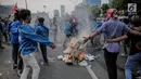 Mahasiswa peserta aksi melakukan pembakaran sejumlah kardus saat menutup tol dalam kota di depan Gedung DPR/ MPR RI, Jakarta, Selasa (24/9/2019). Demonstrasi mahasiswa di depan Gedung DPR ini di antaranya menuntut penolakan atas pengesahan sejumlah RUU kontroversial. (Liputan6.com/Faizal Fanani)