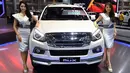 Dua model berpose di samping ISUZU MU-X 2019 selama Thailand International Motor Expo di Bangkok (29/11). (AFP Photo/Lillian Suwanrumpha)