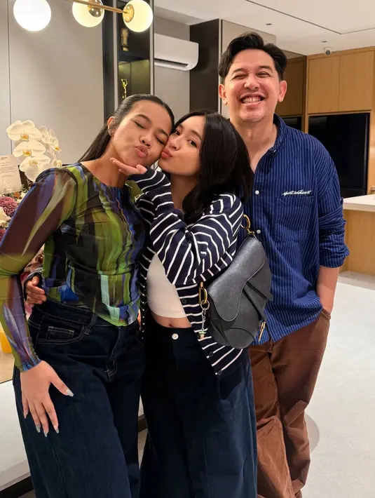 Elsa Japasal hadir mengenakan inner tanktop putih dipadukan luaran cardigan bergaris hitam putih serta bawahan celana denim. Sambil membawa tas Dior hitam. [@elsaajapasal]