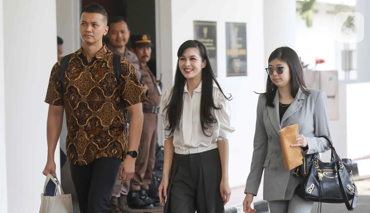 Artis Sandra Dewi (tengah) berjalan ke ruangan pemeriksaan setibanya di Gedung Kejaksaan Agung RI, Jakarta, Kamis (4/4/2024). (Liputan6.com/Herman Zakharia)