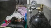 Seorang pasien COVID-19 menerima oksigen di koridor bangsal gawat darurat rumah sakit di Kathmandu, Rabu (5/5/2021). Lockdown di ibu kota Kathmandu dan distrik sekitarnya diperpanjang ketika negara Himalaya mencatat infeksi harian COVID-19 dan kematian tertinggi. (AP Photo/Niranjan Shrestha)