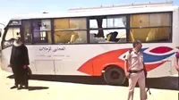 Petugas polisi dan seorang pastur berada di dekat bus yang diserang oleh sekelompok orang bertopeng di Minya, Mesir, (26/5). Jamaah Kristen Koptik merupakan minoritas di Mesir. (Minya Governorate Media office via AP)