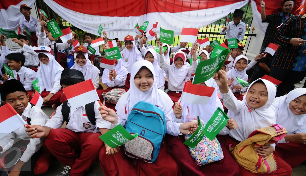 Pelajar SD mengibarkan bendera kedua negara untuk menyambut kedatangan Presiden Joko Widodo bersama Raja Arab Saudi, Salman bin Abdulaziz di sekitar Istana Bogor, Rabu (1/3). Puluhan ribu pelajar akan menyambut. (Liputan6.com/Helmi Fithriansyah)