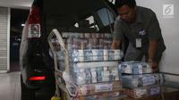 Petugas memasukkan lembaran uang rupiah ke dalam mobil di Bank Mandiri, Jakarta, Kamis (21/12). Guna memenuhi kebutuhan uang tunai selama perayaan Natal dan Tahun Baru 2018, BI menyiapkan uang kartal sebanyak Rp 193,9 triliun. (Liputan6.com/Angga Yuniar)