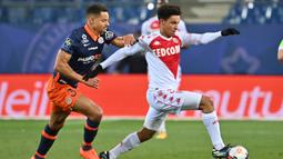 Gelandang AS Monaco, Sofiane Diop melepaskan diri dari hadangan bek Montpellier, Daniel Congre dalam laga lanjutan Liga Prancis 2020/21 pekan ke-20 di Mosson Stadium, Montpellier, Jumat (15/1/2021). AS Monaco menang 3-2 atas Montpellier. (AFP/Pascal Guyot)