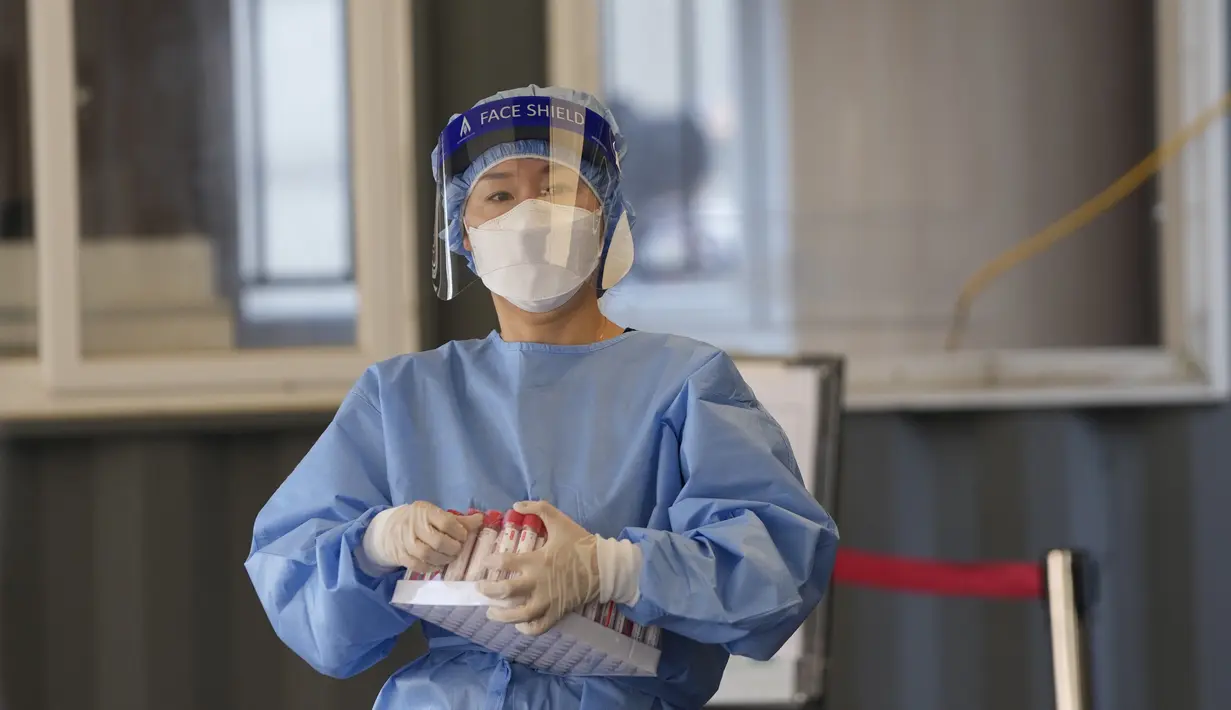 Pekerja medis mengenakan alat pelindung bersiap untuk mengambil sampel di klinik skrining sementara untuk virus corona di Seoul, Korea Selatan, Jumat (24/9/2021). Korea Selatan telah melaporkan lonjakan harian terbesar virus corona sejak dimulainya pandemi. (AP Photo/Lee Jin-man)