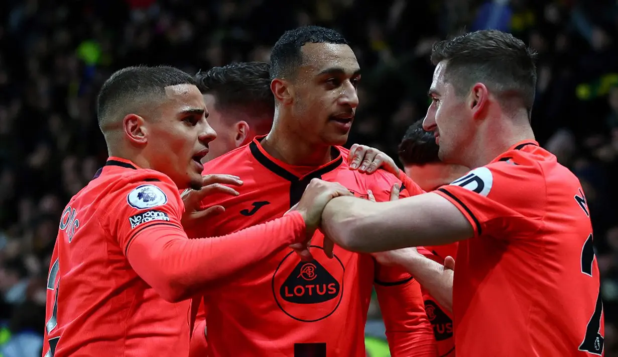 Pemain Norwich City Adam Idah (tengah) merayakan setelah gelandang Watford Juraj Kucka (tidak terlihat) mencetak gol bunuh diri pada pertandingan sepak bola Liga Inggris di Vicarage Road Stadium, Watford, Inggris, Sabtu (22/1/2022). Norwich City menang 3-0. (Adrian DENNIS/AFP)