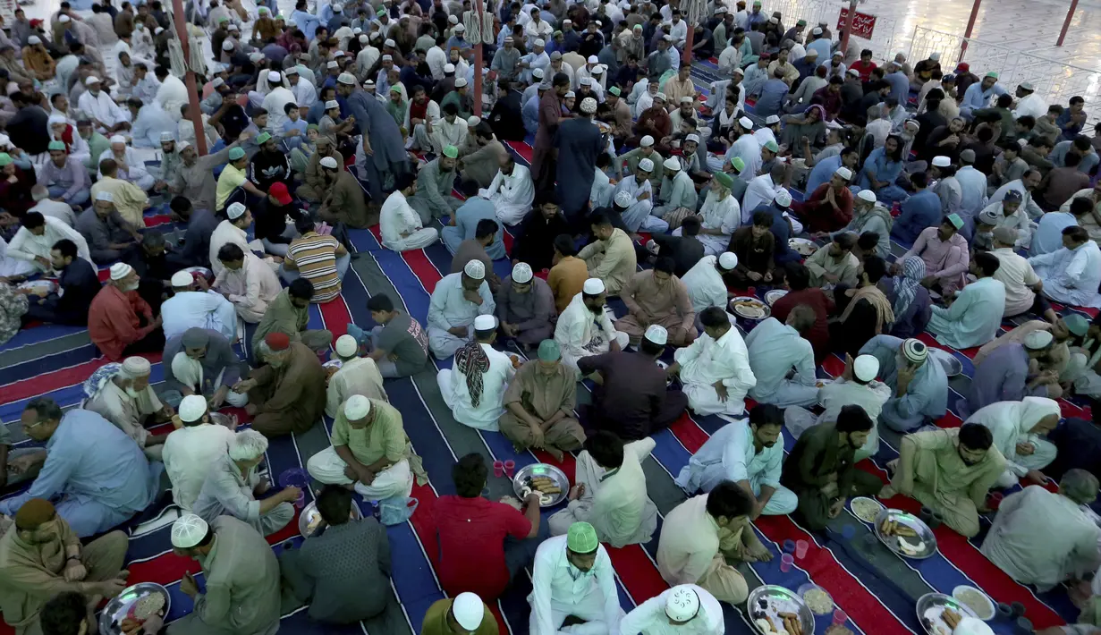 Sejumlah umat Muslim berbuka puasa di masjid, selama bulan suci puasa Ramadhan, di Karachi, Pakistan, Rabu (14/4/2021). Bulan Ramadhan ditandai dengan berpuasa setiap hari dari fajar hingga matahari terbenam. (AP Photo/Fareed Khan)