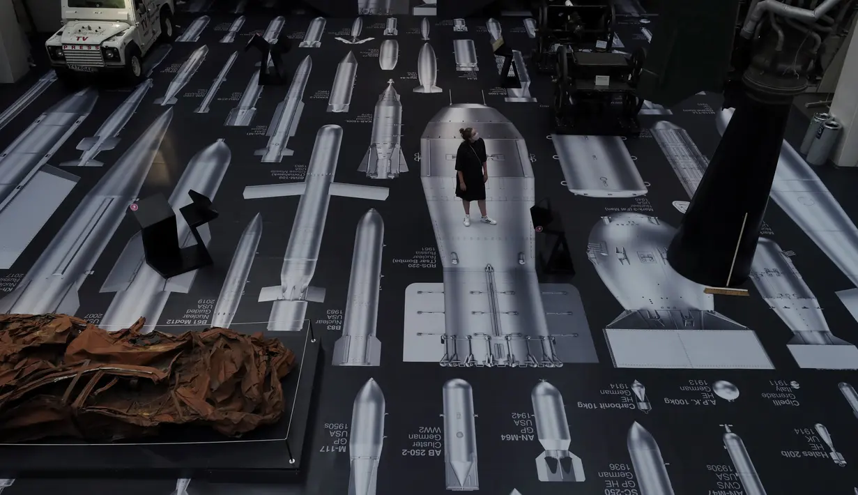 Pekerja berpose dengan karya seniman China Ai Weiwei berjudul History of Bombs di Imperial War Museum, London, Inggris, Rabu (29/7/2020). Imperial War Museum akan kembali dibuka pada 1 Agustus 2020 setelah pemerintah Inggris terus melonggarkan lockdown. (AP Photo/Matt Dunham)