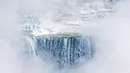 Es dan air mengalir di tepi Horseshoe Falls dari Air Terjun Niagara di Ontario, Kanada, Kamis (31/1). Cuaca dingin yang melanda Amerika Serikat (AS) membuat sebagian Air Terjun Niagara membeku. (Tara Walton/The Canadian Press via AP)