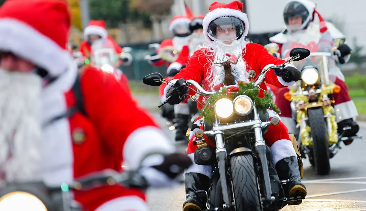 Pengendara motor besar berpakaian seperti Sinterklas menyusuri jalanan selama acara amal di Lustadt, Jerman, Kamis (6/12). Mereka mengumpulkan sumbangan untuk rumah sakit Sterntaler di Speyer, yang merawat anak-anak penderita kanker. (Uwe Anspach/dpa/AFP)