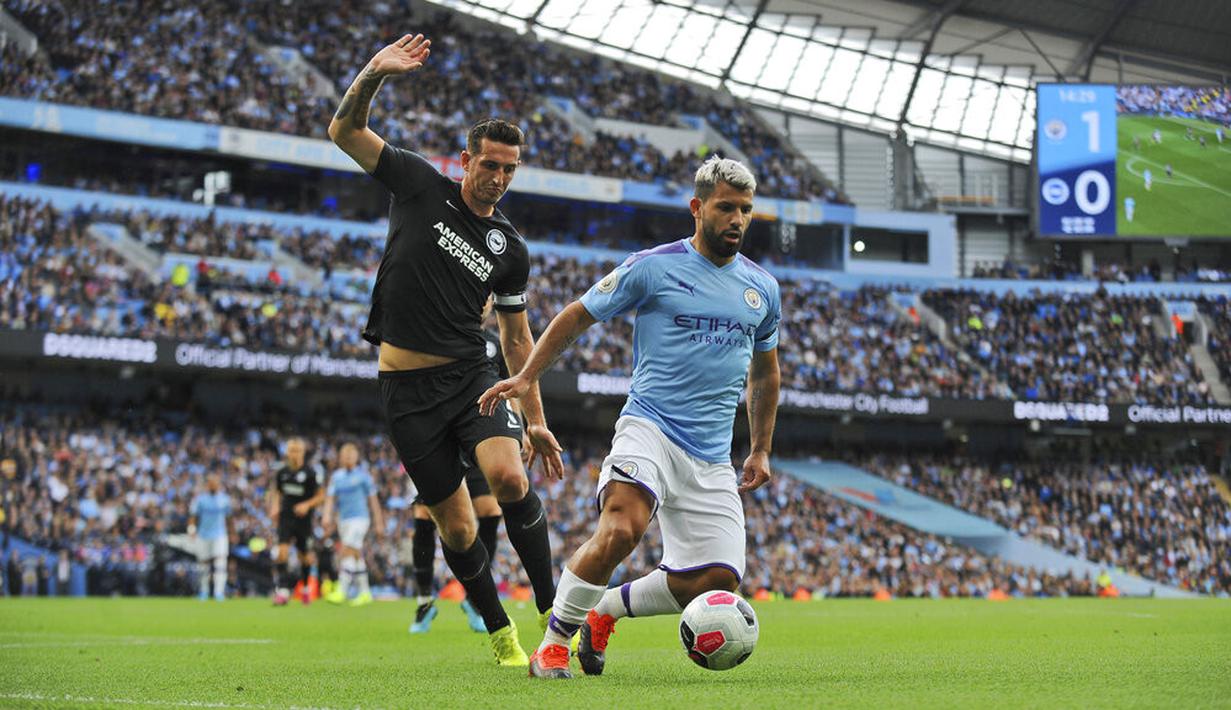 Striker Manchester City, Sergio Aguero, berusaha melawati pemain Brighton and Hove Albion, Lewis Dunk, pada laga Premier Leauge 2019 di Stadion Etihad, Sabtu (31/8). Manchester City menang 4 gol tanpa balas. (AP/Rui Vieira)