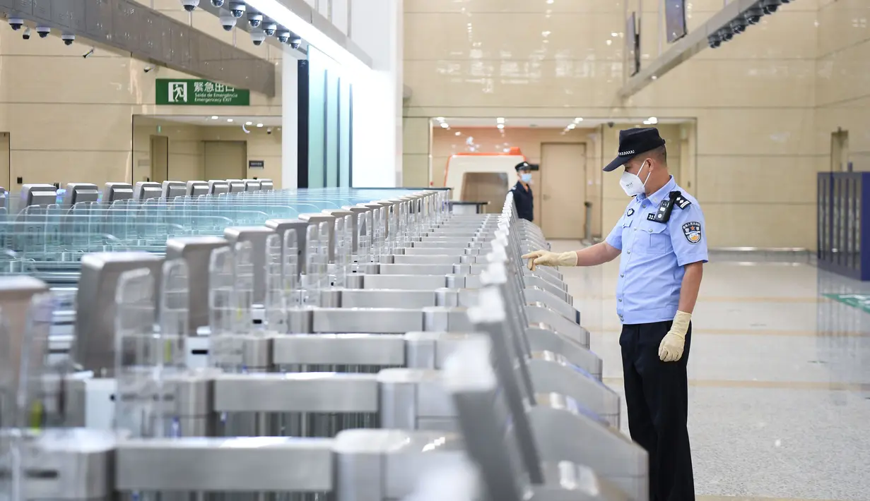 Seorang polisi dari Zhuhai memeriksa jalur inspeksi otomatis di Pelabuhan Hengqin pada 18 Agustus 2020. Pelabuhan baru untuk memfasilitasi perjalanan antara Makau dan Zhuhai, Provinsi Guangdong, China selatan, ini resmi beroperasi pada Selasa (18/8). (Xinhua/Deng Hua)