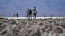 Orang-orang mengunjungi dataran garam di Badwater Basin, di Taman Nasional Death Valley, Taman Nasional Death Valley, California, Kamis (1/9/2022). Kondisi yang terlalu panas ini bisa menyebabkan manusia mengalami dehidrasi dan merusak kendaraan bermotor yang melintas.  (AP Photo/John Locher)