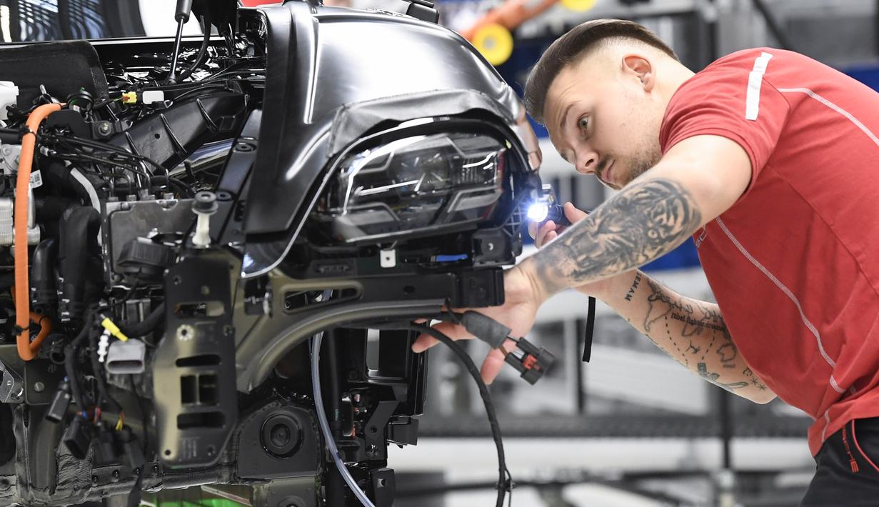 Mekanik mengecek lampu depan mobil listrik Porsche Taycan saat proses perakitan di pabrik perusahaan Porsche AG di Stuttgart, Jerman, Rabu (4/3/2020). Porsche Taycan merupakan mobil bertenaga listrik pertama  dari pembuat mobil mewah Jerman, Porsche AG. (AFP Photo/Thomas Kienzie)