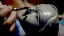 Seorang perajin mengerjakan wajah patung tanah liat dewi Hindu Durga di sebuah lokakarya menjelang festival Durga Puja di Vashi di Navi Mumbai (23/9/2021). Durga Puja  adalah festival tahunan di Asia Selatan untuk memuja dewi Durga dari agama Hindu. (AFP/Indranil Mukherjee)