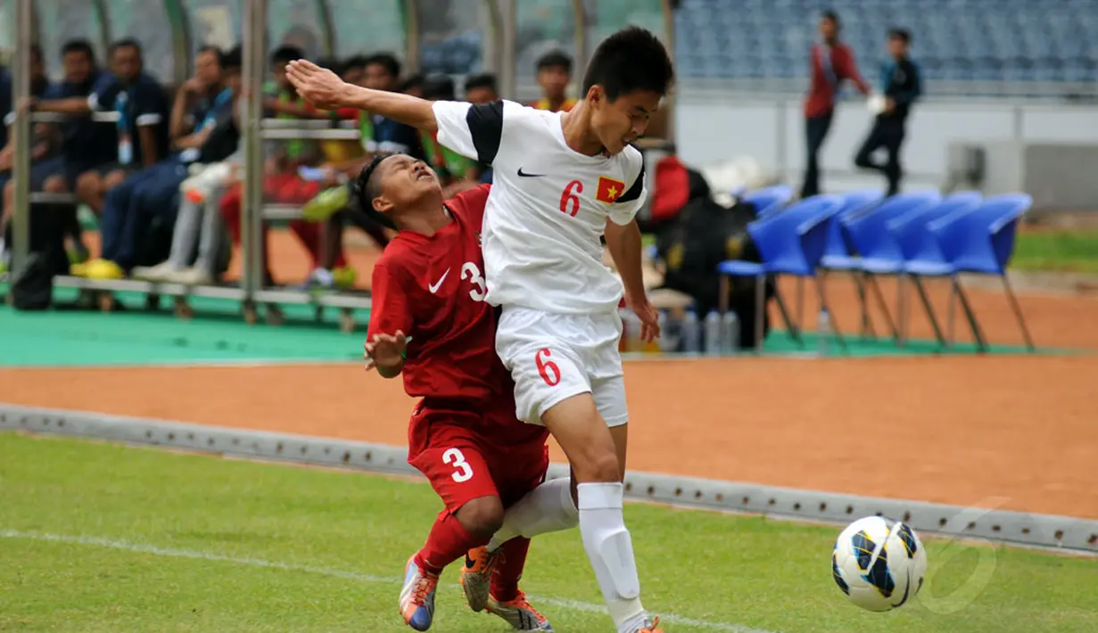 Pemain belakang timnas U-16 Vietnam, Quach Cong Dinh (kanan) menghalangi pergerakan Rian Riding (Indonesia - kiri) saat berlaga di Stadion GBK Jakarta, (3/12). Timnas U-16 Indonesia unggul 3-2 atas Timnas U-16 Vietnam. (Liputan6.com/Helmi Fithriansyah)