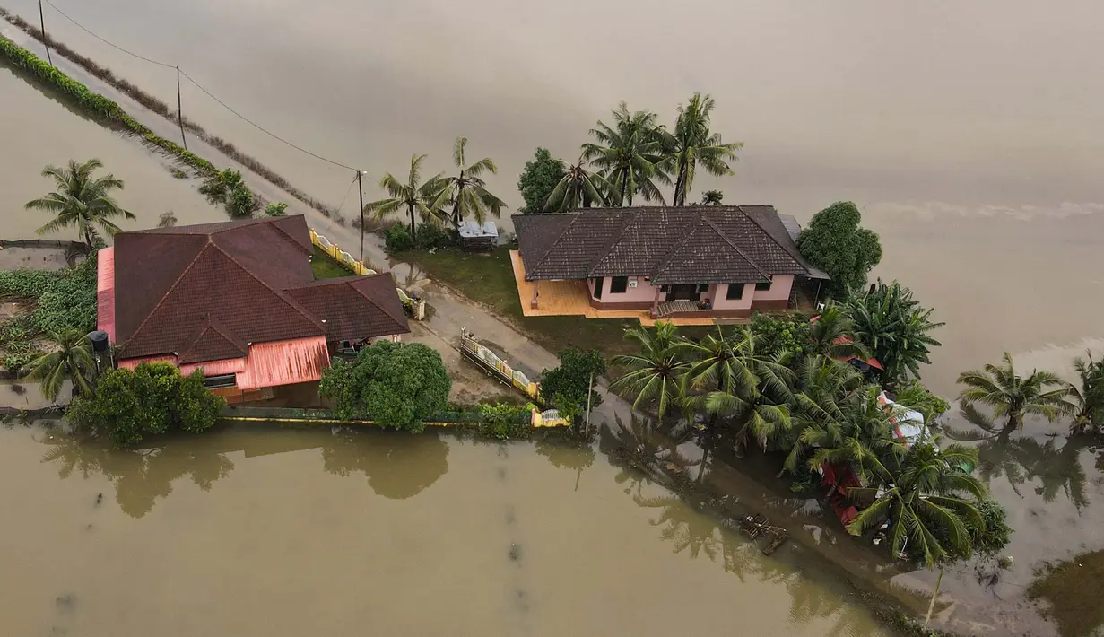 Foto udara menunjukkan dua rumah yang dikelilingi oleh banjir setelah hujan lebat di Kota Bharu, negara bagian Kelantan, Malaysia pada tanggal 1 Desember 2024. (MOHD RASFAN/AFP)
