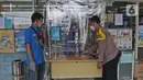 Petugas sedang berbelanja di minimarket di Jalan As-Syafiiyah, Cipayung, Jakarta Timur, Jumat (21/5/2021). Kawasan tersebut memberlakukan mikro lockdown serta tes usap PCR secara massal. (Liputan6.com/Herman Zakharia)