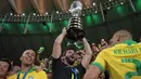 Kiper Timnas Brasil, Alisson mengangkat trofi Copa America 2019 saat berselebrasi bersama rekan setimnya setelah mengalahkan Peru pada partai final di Maracana Stadium, Rio de Janeiro, Senin (8/7/2019) dini hari WIB. Brasil menundukkan Peru dengan skor 3-1. (Carl DE SOUZA/AFP)