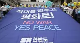 Para aktivis Korea Selatan memegang spanduk besar bertuliskan 