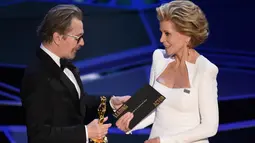 Gary Oldman saat menerima penghargaan dalam Oscar 2018 di Dolby Theater, Los Angeles, Amerika Serikat, Minggu (4/3). Perannya sebagai Winston Churchill di Darkest Hour berhasil membawa pulang Oscar. (Chris Pizzello/Invision/AP)