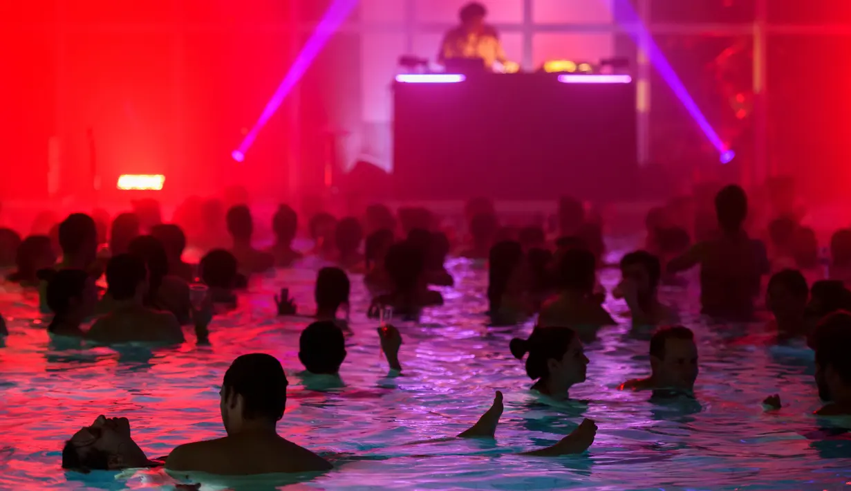 Sejumlah orang menikmati musik DJ Luke Abbott di kolam renang di hotel Cressy selama Festival Antigel (Festival Anti Beku) di Confignon, Jenewa, Swiss (30/1). Festival Antigel ini berlangsung dari 27 Januari-19 Februari 2017. (AFP Photo/Fabrice Coffrini)