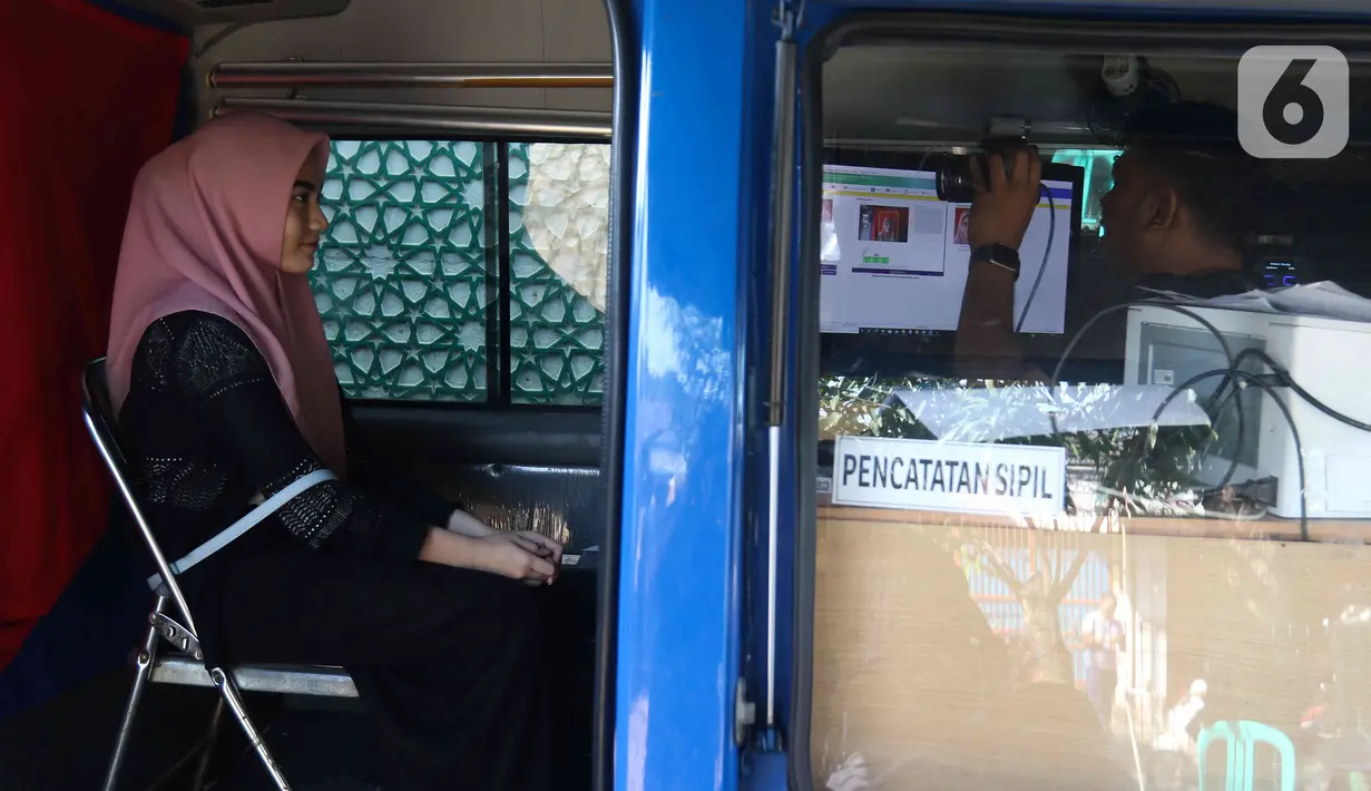 Seorang warga melakukan proses administrasi perubahan nama jalan pada KTP elektronik di Halaman Masjid Al Hikmah Hidayah, Cipayung, Jakarta Timur, Rabu (29/6/2022). Pemprov DKI Jakarta menggelar pelayanan jemput bola di enam wilayah terkait perubahan data administrasi kependudukan imbas pergantian 22 nama jalan menggunakan nama tokoh Betawi. (Liputan6.com/Herman Zakharia)