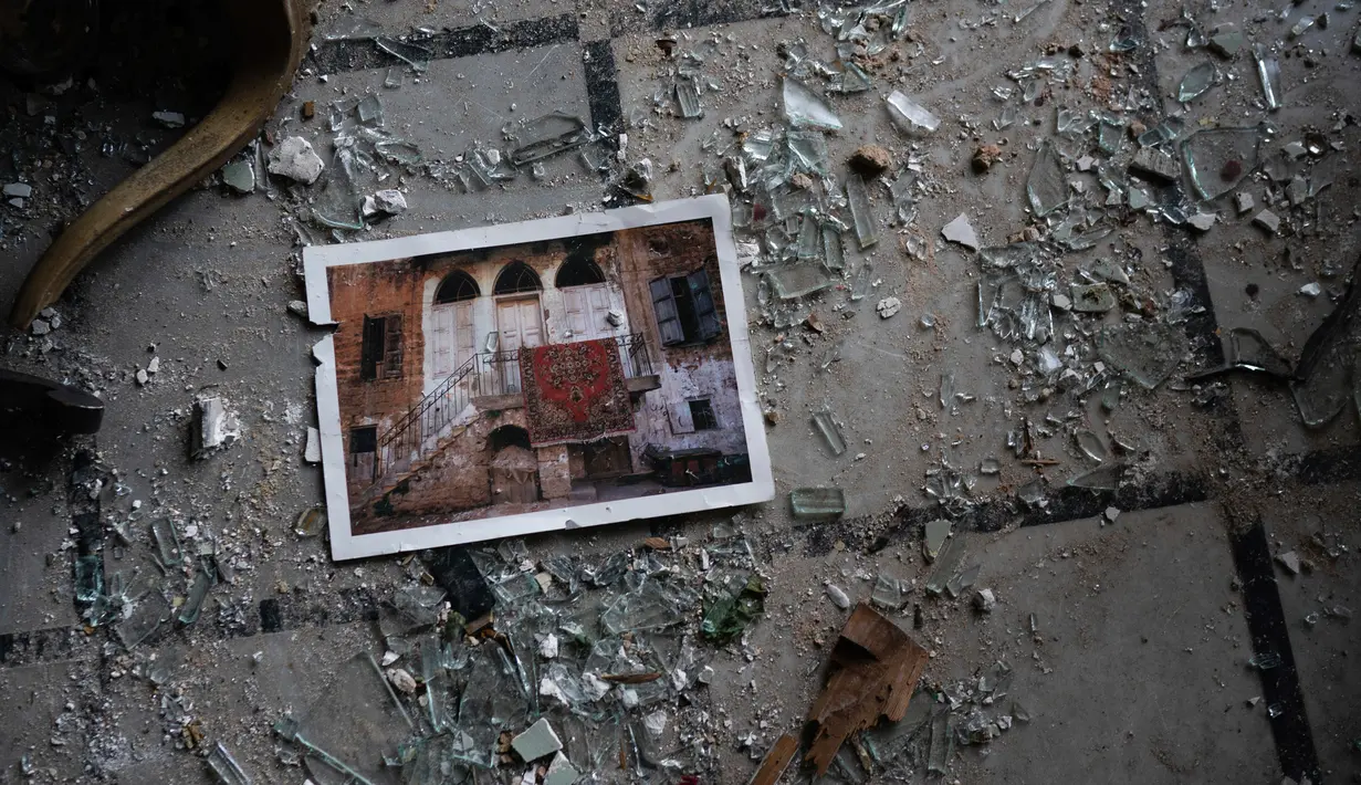 Sebuah foto tergeletak di antara pecahan kaca di lantai Istana Sursock yang rusak berat pascaledakan di Beirut, Lebanon, 7 Agustus 2020. Setelah perang saudara 1975-1990 di negara itu, butuh 20 tahun pemulihan yang cermat bagi keluarga untuk mengembalikan istana ke kejayaannya (AP Photo/Felipe Dana)