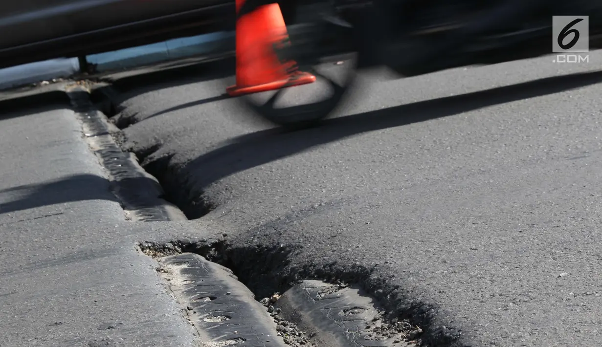 Kondisi salah satu ruas jalan layang yang retak di kawasan Kemayoran, Jakarta, Kamis (3/1). Akibat retakan ini, para pengendara harus lebih berhati-hati saat melintas. (Liputan6.com/Helmi Fithriansyah)