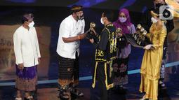 Menteri Pariwisata dan Eknomi Kreatif Sandiaga Salahuddin Uno (kanan) memberikan penghargaan pada ADWI 2021 di Jakarta, Selasa malam (7/12/2021). ADWI 2021 bertajuk "Indonesia Bangkit”  diharapkan dapat mewujudkan pembangunan ekonomi yang berkelanjutan. (Liputan6.com/Fery Pradolo)