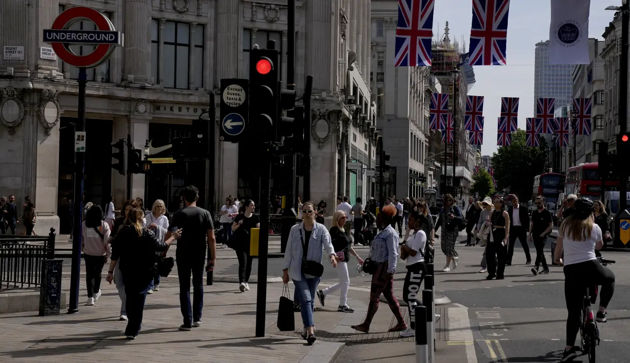 <p>Orang-orang berjalan di distrik perbelanjaan Oxford Circus, London, Rabu (18/5/2022). Tingkat inflasi Inggris naik ke level tertinggi dalam 40 tahun pada bulan April karena invasi Rusia ke Ukraina memicu kenaikan lebih lanjut dalam harga makanan dan bahan bakar. (AP Photo/Matt Dunham)</p>